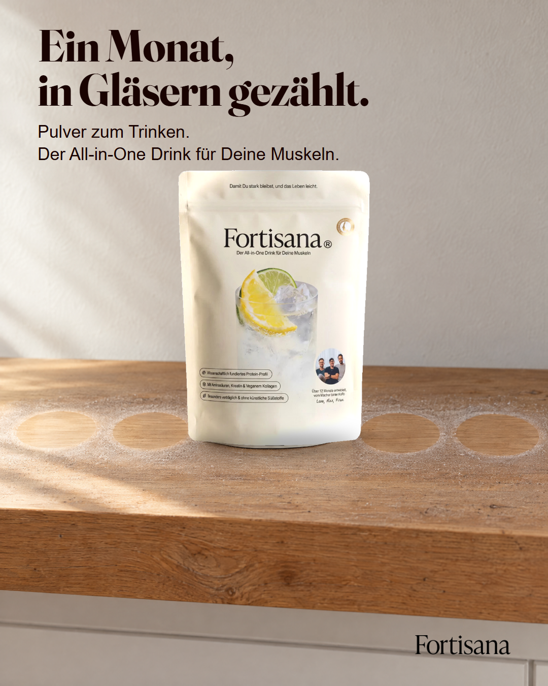 Der Fortisana Monatsbeutel auf einem Holzregal, daneben eine Reihe runder Glasabdrücke in verschüttetem Pulver